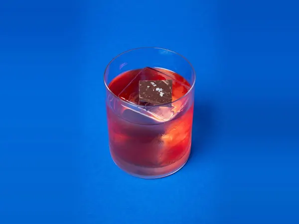 Chiyonofuji Oolong Negroni no copo baixo, com quadrado de chocolate